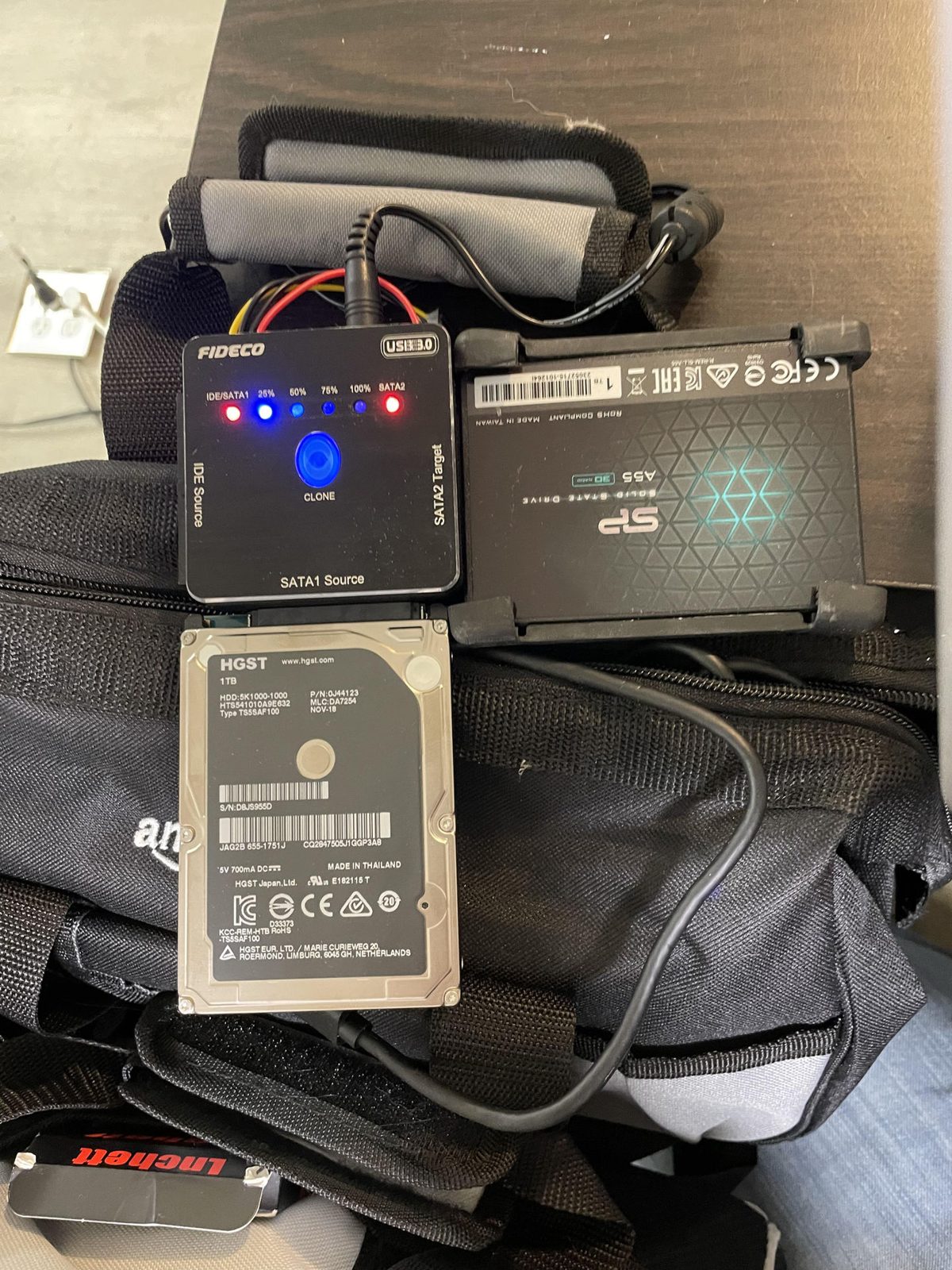 Battery charger with battery, SD card, and computer on a bag Computer Repair Progress