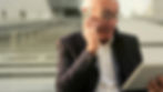A senior man using a smartphone and tablet outdoors, showcasing modern technology engagement.